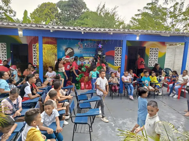 Estudiantes y familias reunidos en el patio, junto a un árbol de Navidad.